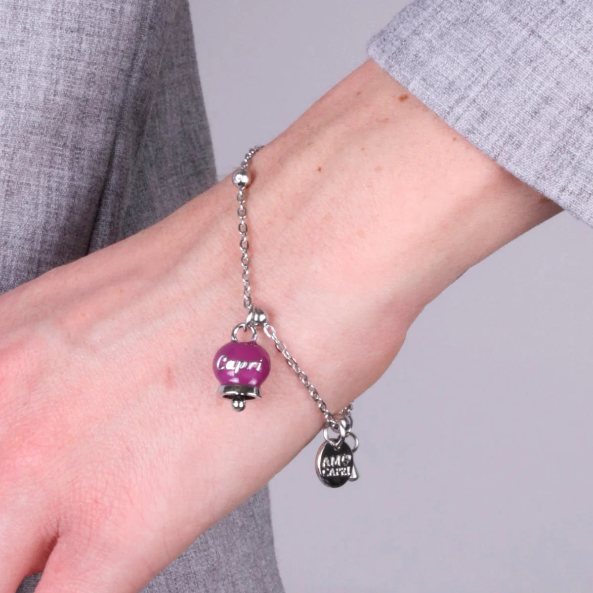 AMO CAPRI - BRACCIALE IN ACCIAIO CON CAMPANELLA PICCOLA BORGOGNA SCRITTA CAPRI