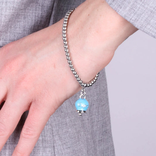 AMO CAPRI - BRACCIALE IN ACCIAIO CON CAMPANELLA PICCOLA TURCHESE SCRITTA CAPRI