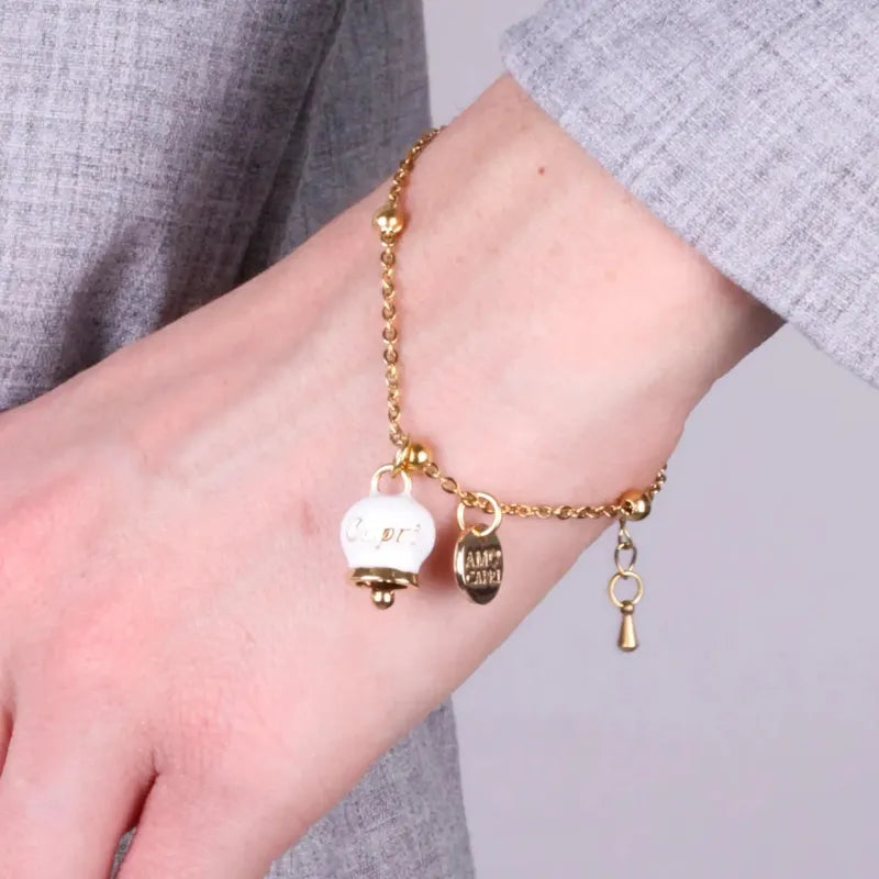 AMO CAPRI - BRACCIALE IN ACCIAIO DORATO MINI CAMPANELLA BIANCA SCRITTA CAPRI
