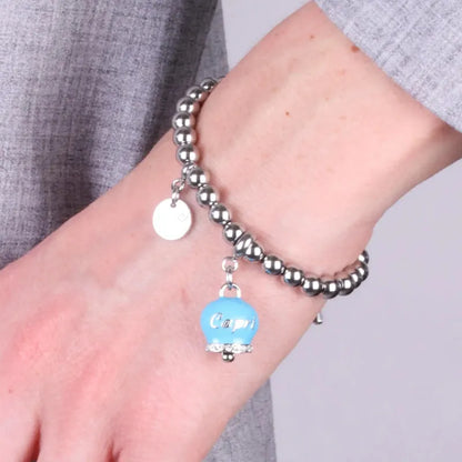 AMO CAPRI - BRACCIALE IN ACCIAIO CON CAMPANELLA TURCHESE SCRITTA CAPRI E CRISTALLI