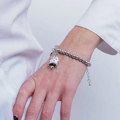 AMO CAPRI - BRACCIALE IN ACCIAIO CON CAMPANELLA BIANCA E POIS BLU