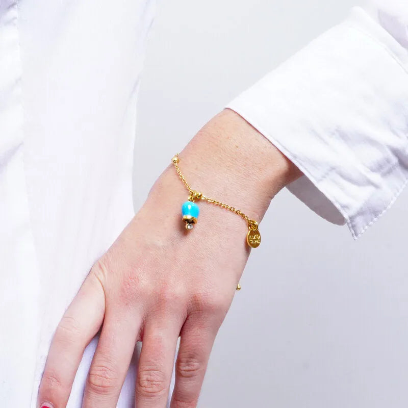 AMO CAPRI - BRACCIALE IN ACCIAIO DORATO MINI CAMPANELLA AZZURRA E CRISTALLO